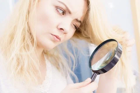 Woman magnifying her split ends hair Stock Photos