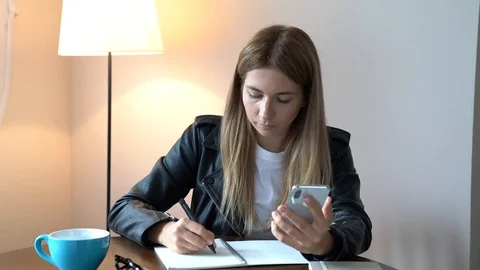 Woman make a notes and tapping a smartphones 4k Stock Footage 113288207