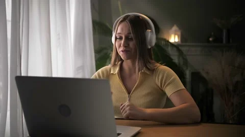 Woman make video call using laptop sitting at table in home interior.Young girl Stock Footage 209825566