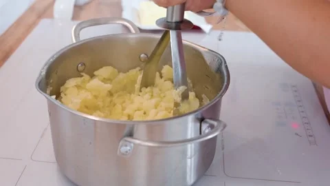 A woman makes mashed potatoes in the kitchen Stock Footage 318463830