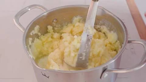 A woman makes mashed potatoes in the kitchen Stock Footage 318463836