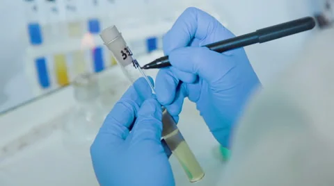 Woman makes note with marker on test tube Stock Footage 59982610