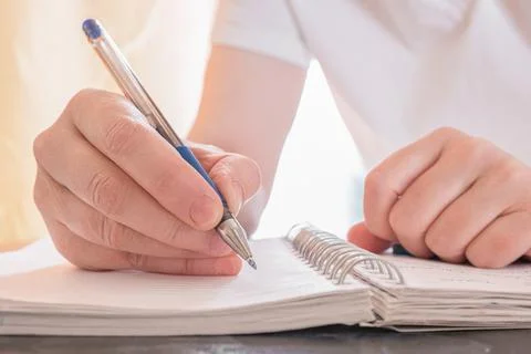 The woman makes notes in notebook. Concept of education, business, writing. Stock Photos