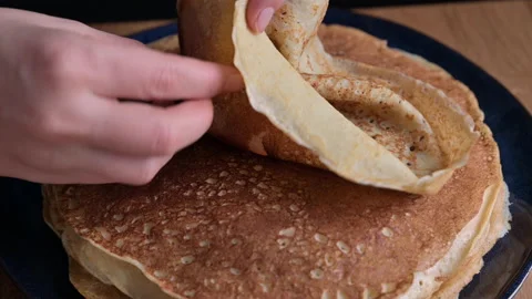 The woman makes a serving portion. Russian thin pancakes with salmon caviar and Stock Footage 146144744