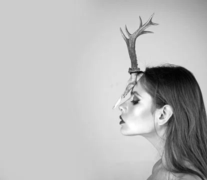 Woman with makeup and antlers. Fashion devil of mystic shaman girl with horns Stock Photos