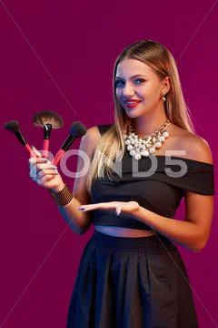 Woman makeup artist standing with brushes Stock Photos