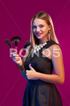 Woman makeup artist standing with brushes Stock Photos