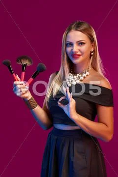 Woman makeup artist standing with brushes Stock Photos