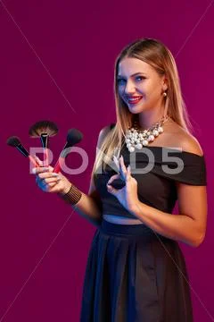 Woman makeup artist standing with brushes Stock Photos