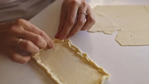 Woman making borders on rectangular dough on white table Vídeos de archivo 305045992
