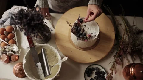 Woman making cake at kitchen workplace. Chef decorates a cake with berries and Stock Footage 143996724