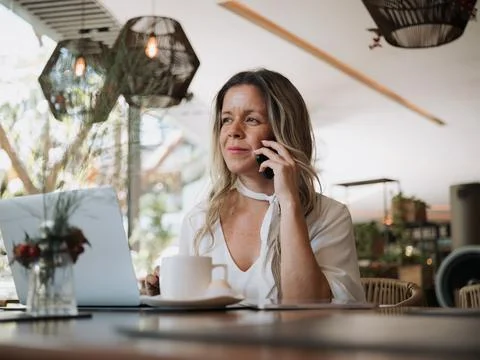 Woman making call while working Stock Photos