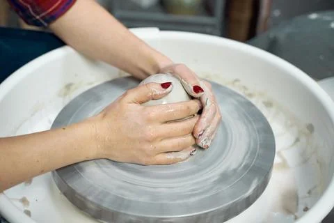 Woman making ceramic pottery, four hands close-up, focus on potters, palms with Stock Photos