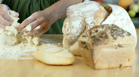 Woman making dough in the kitchen on the wooden table, dolly shot Stock Footage