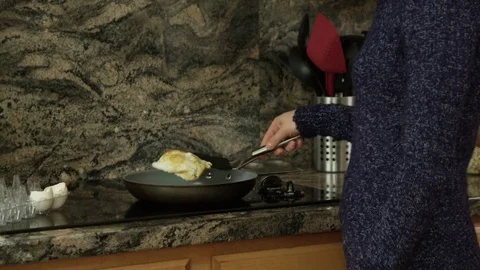Woman making eggs in a pan Stock Footage 69889221