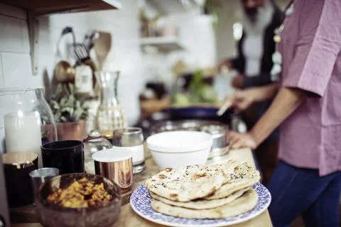 Woman making flatbread at kitchen stove Stock Photos