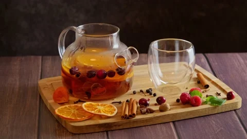 Woman making fruit tea with orange, cranberries, cinnamon, adding ingredients Stock Footage 222812612