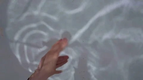 Woman Making Hand Shadow Puppet on the Background of Water Glare 動画素材 84768758