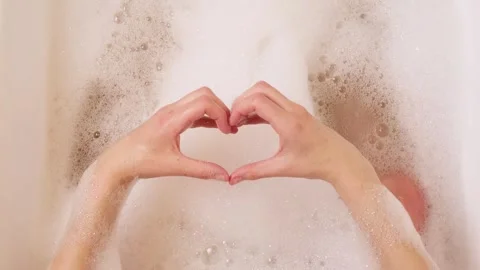 Woman making heart shape with hands over bath foam Stock Footage 328535625