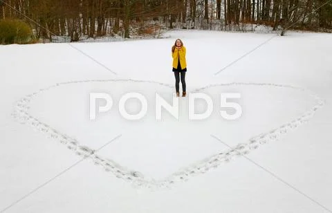 Woman Making Heart Shape In Snow