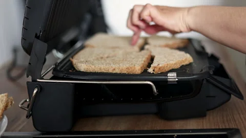 Woman making in kitchen bread in electric grill.toast Stock-Footage 242990848