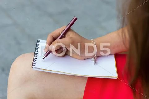 Woman Making Notes In The Note Book Onthe Street