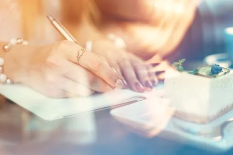 Woman making notes while sitting in a coffee shop Stock Photos