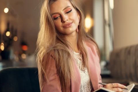 Woman making notes while sitting in a coffee shop Stock Photos