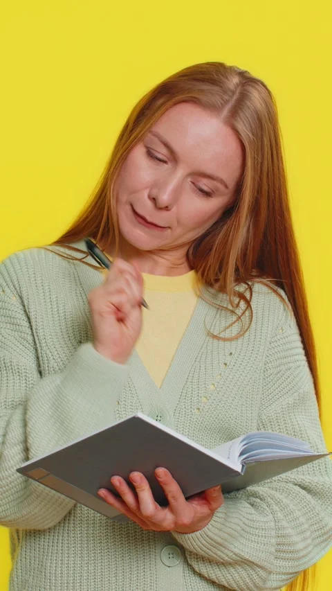 Woman making notes writing down thoughts with pen into notepad notebook diary to Stock Footage 314595256