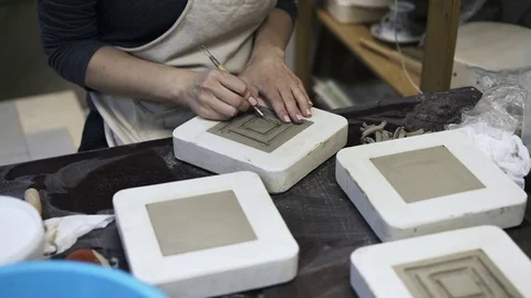 Woman making pattern on clay pieces Stock Footage 75289014
