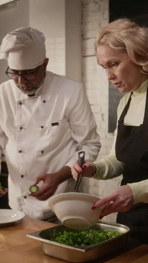 Woman Making Salad with Chef at Cooking Master Class Stock Footage 332575005