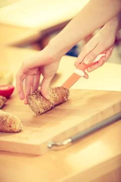 Woman making sandwich cutting bread Stock Photos
