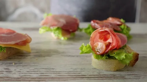 Woman making sandwich with salad leaf, spread, cherry tomatoes Stock Footage 80542001