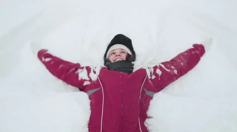 Woman making snow angel Stock Footage 59776661