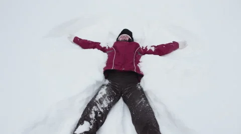 Woman making snow angel Stock Footage 59776670