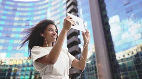 Woman making a video call via computer tablet in a big city Stock Footage 64777867