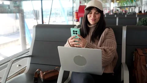 Woman making video call while waiting at airport terminal Stock Footage 334383766