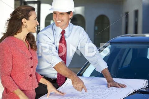 Woman & man in hard hat on construction site Stock Photos