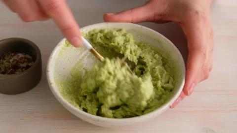 Woman mashed avocado to make a whole grain sandwich with avocado, eggs, flax Stock Footage 131275868