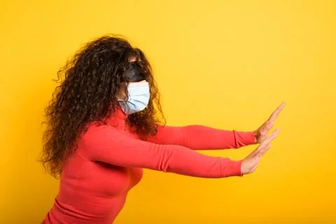 Woman with mask and blindfold. concept of uncertainty. yellow background Stock Photos