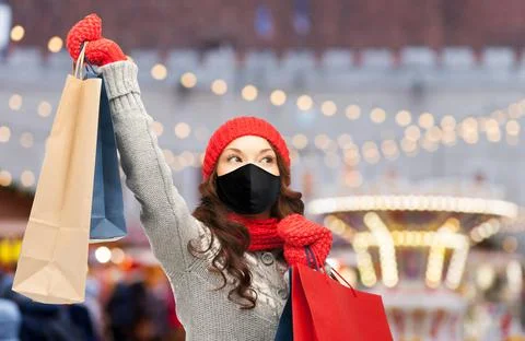 Woman in mask with shopping bags on christmas Stock Photos