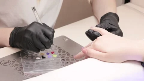 Woman master manicure draws a pattern on the nails. Stock Footage 131027191