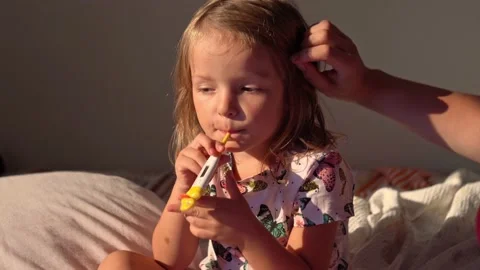 Woman measuring temperature of small girl Stock Footage 166375627