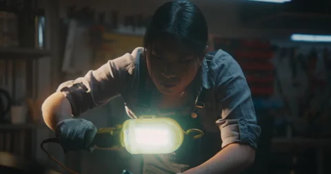 Woman Mechanic Inspecting Engine with Work Light Stock Footage 330266786