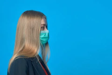 A woman in a medical mask on a blue background Stock Photos