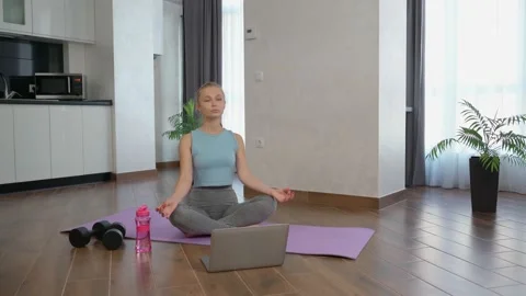 Woman meditating during online tutorial on laptop Vídeo Stock 147134082