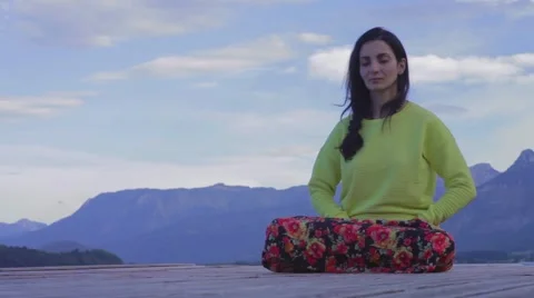 A woman is meditating on pier Stock Footage