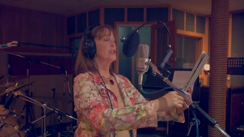 Woman at mic in recording studio, medium shot,facing right Stock Footage 221274293