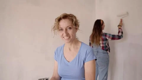 Woman middle aged looking at the camera. Woman friends making repair together Video stock 168154065