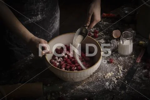 Woman Mixing Raspberries And Sugar In Bowl